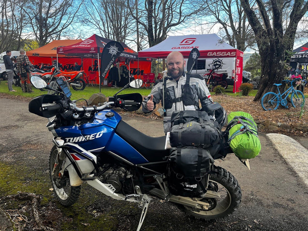 Blue adventure bike with camping gear and rider