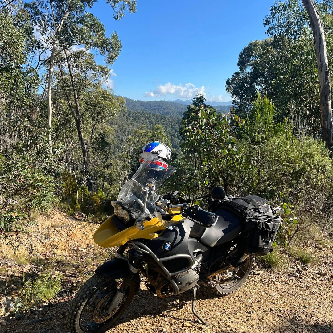 Nomad Moto Adjustable Rackless BMW 1200 GSA Motorcycle on a dirt road with trees and blue sky in the background